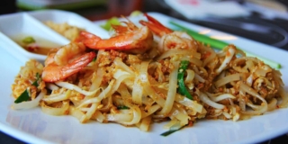 Pad Thai with shrimp on a white plate.