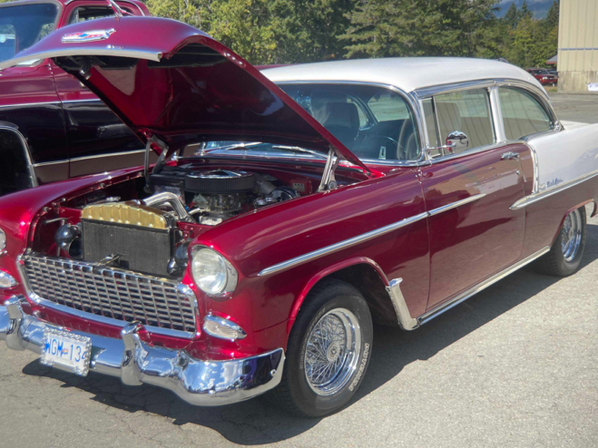 A red Bel Air with a white roof, parked with its hood popped up.