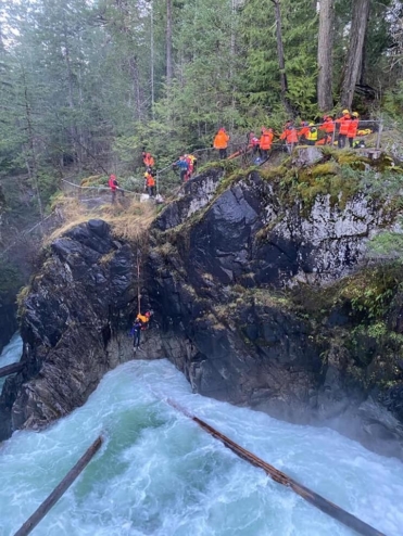 The Arrowsmith Search and Rescue team dangles a rescuer over a cliff into a raging river to bring an unconscious man out of the falls.