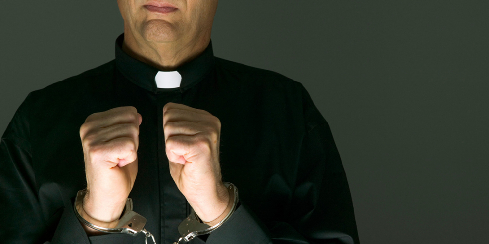 A picture of a priest in handcuffs, but it's cropped above his mouth and below his elbows.