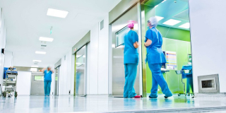 Doctors mingle in a sterile hallway.