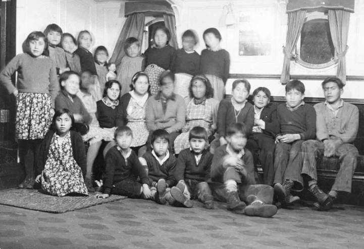 A black-and-white photo of children in sitting room of Alberni Residential School