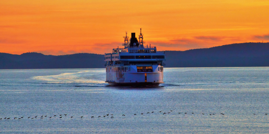 A ferry sails the Salish Sea at sunset.