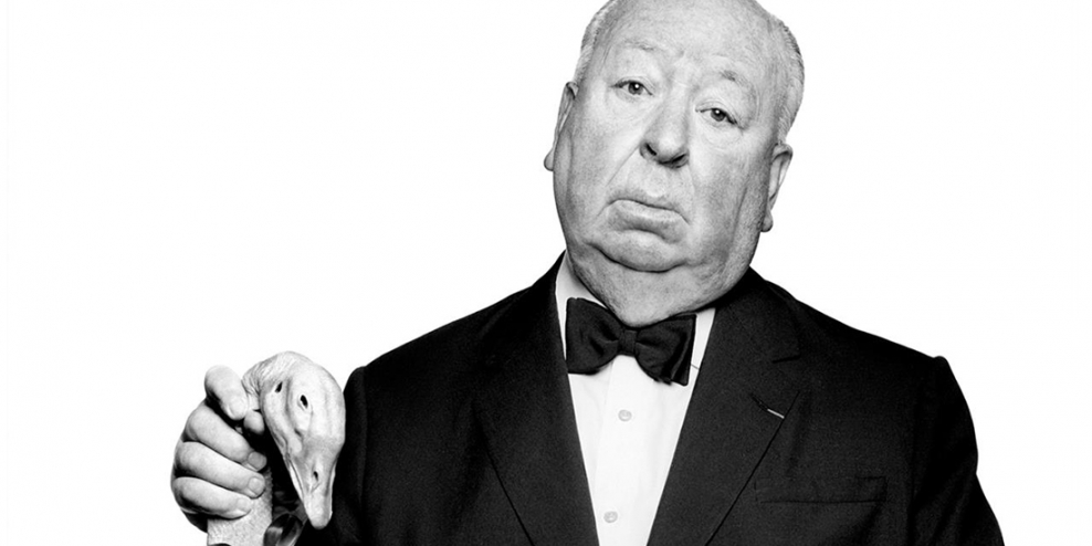 Alfred Hitchcock holding a fake goose head.