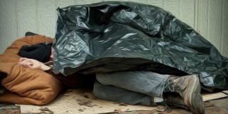 An elderly man sleeps curled up under a garbage bag.
