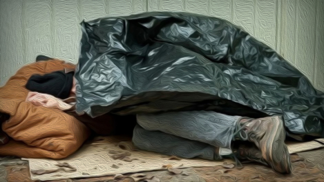 An elderly man sleeps curled up under a garbage bag.