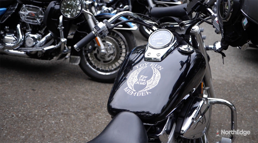 A shiny black motorbike with a decal that reads "For the Kids."