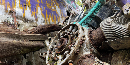 A closeup of a rusted engine on the Canso bomber. It's covered in graffiti.