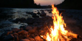 A campfire burns at sunset.
