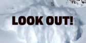 A closeup of a big white avalanche with the words "LOOK OUT!" over top.