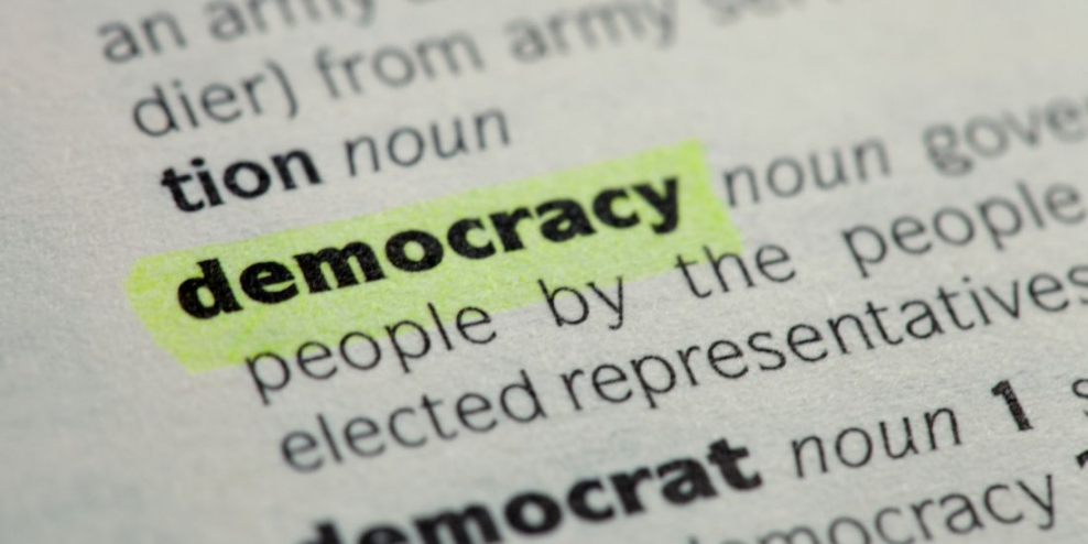 A closeup of the dictionary entry for the word "democracy."