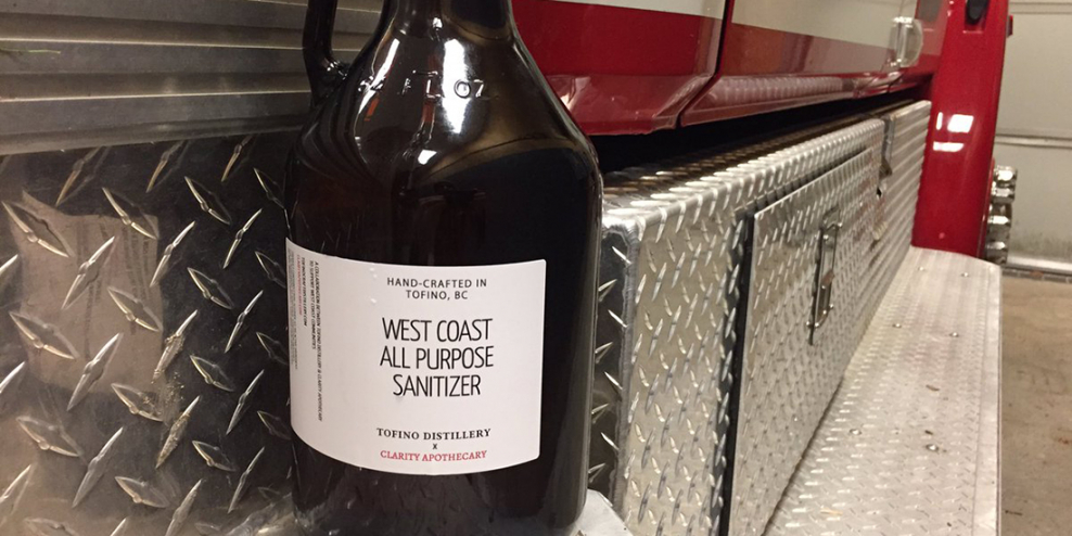 A growler of hand sanitizer brewed in Tofino sits on the running board of a fire truck.