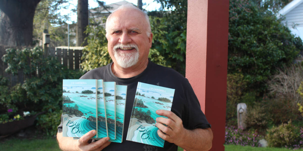 A picture of author John Carswell smiling with a handfull of his books.