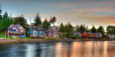 A misty shot of multi-coloured houses on the waterfront in Ucluelet at sunset.