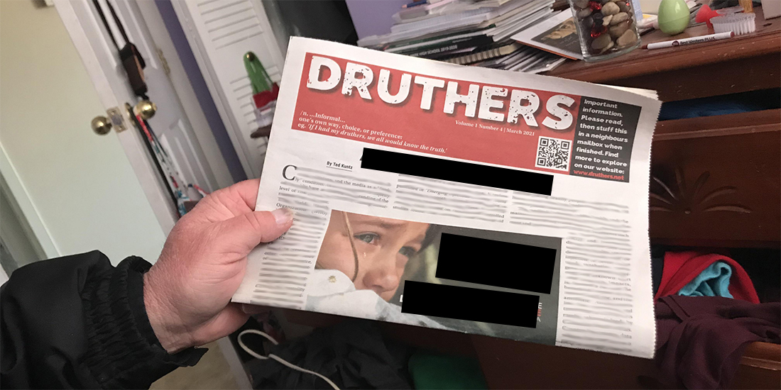 A closeup of someone's hand holding a copy of Druthers. The text is blurred out, but the photo on the front page is of a crying child.