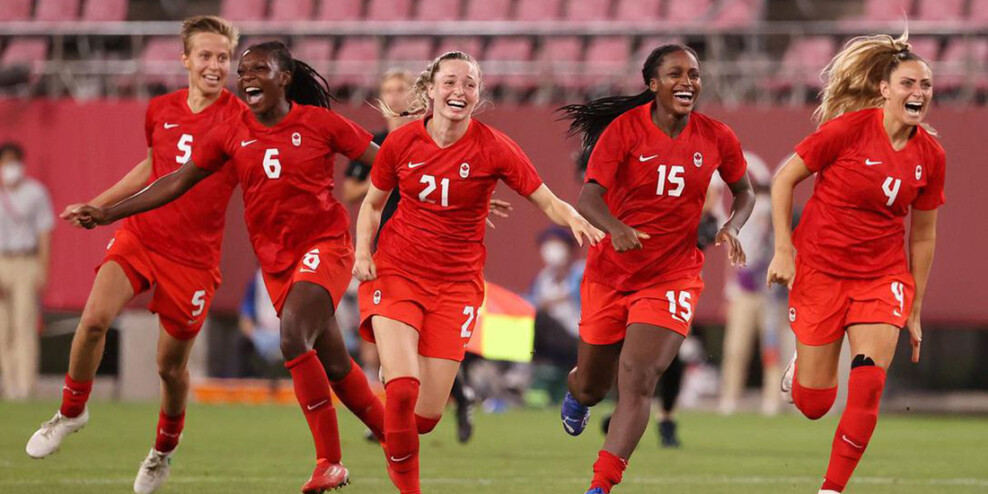 Soccer players on Canada's national team celebrate after winning gold at the Olympics.
