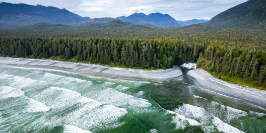 Aerial view of breaker waves and Calvin Falls along the Nootka trail with lots of trees and hills