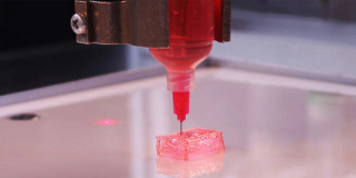 A 3D printer prints a rectangle in a futuristic red material.