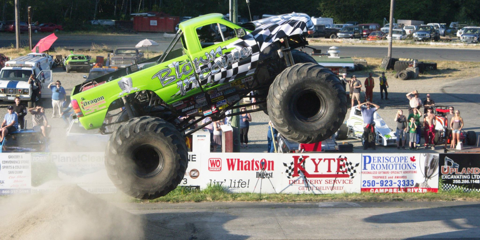 A monster truck catches air at the speedway.