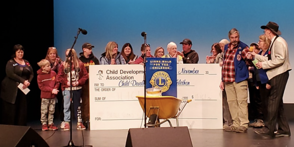 Folks from the CVCDA hold a giant cheque on stage.